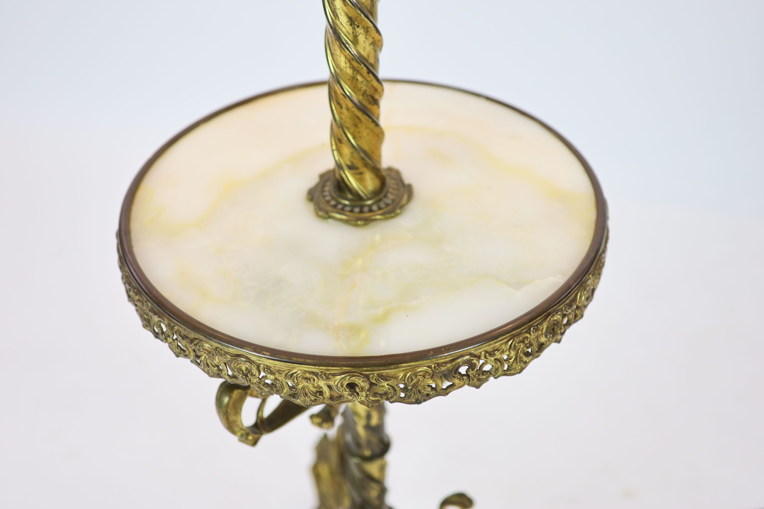 A late Victorian cast brass lamp standard, the column with an alabaster mid tier, raised on an open scrolled tripod base, converted to electricity, height 152cm